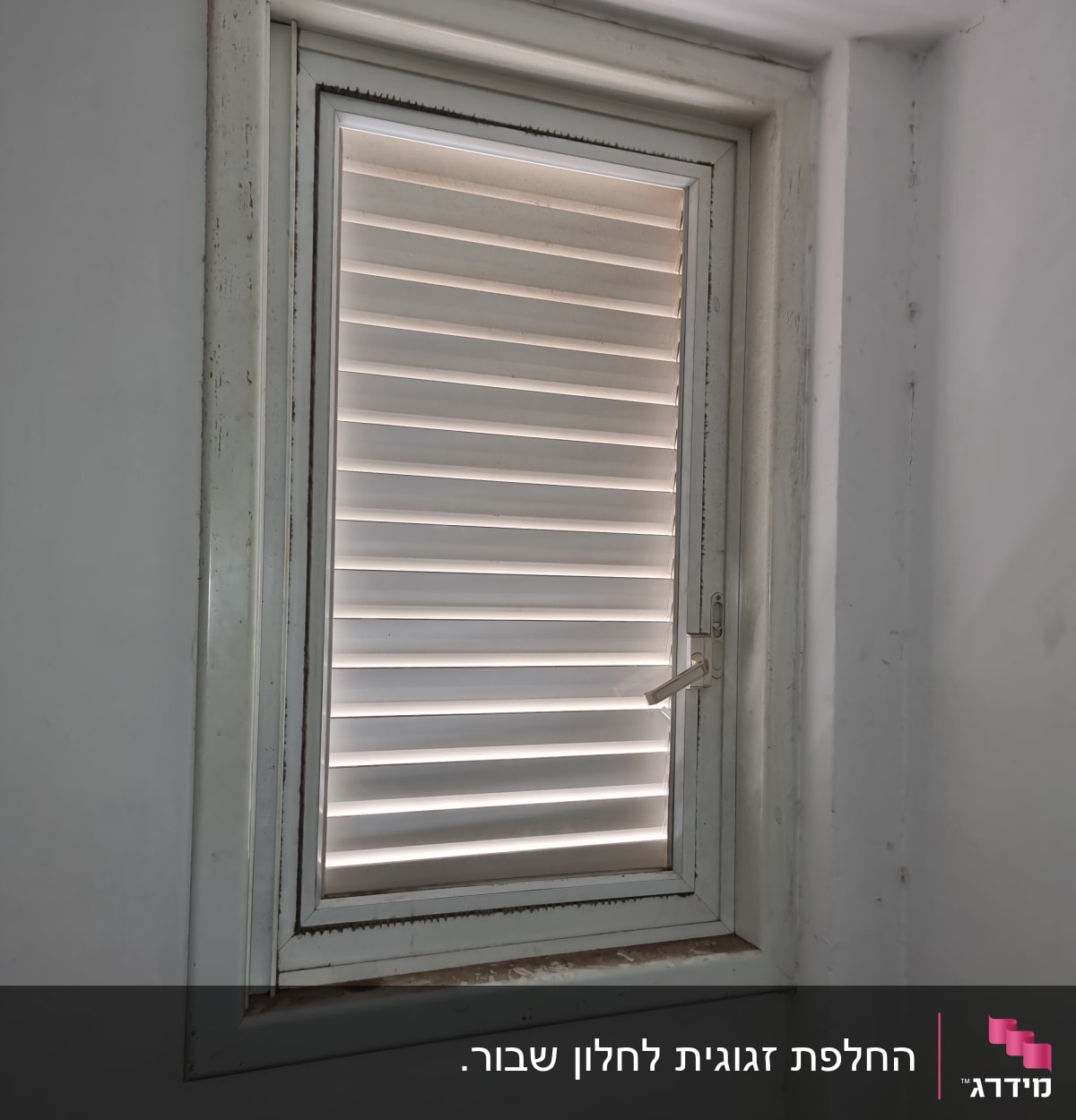 חלון עם תריסים סגורים ומסגרת לבנה
